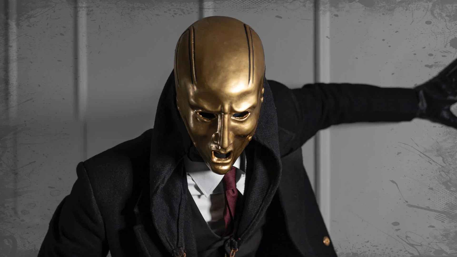 Person in a gold metal mask, dark coat, and tie, evoking industrial techno style